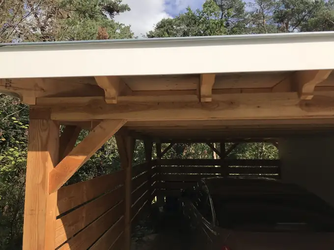 Houten carport op maat naast een woning