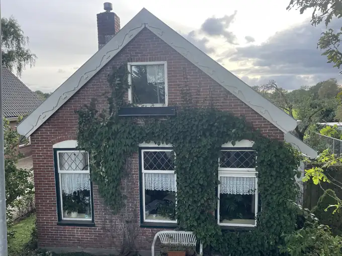 Houten windveren met maatversiering aan een dak